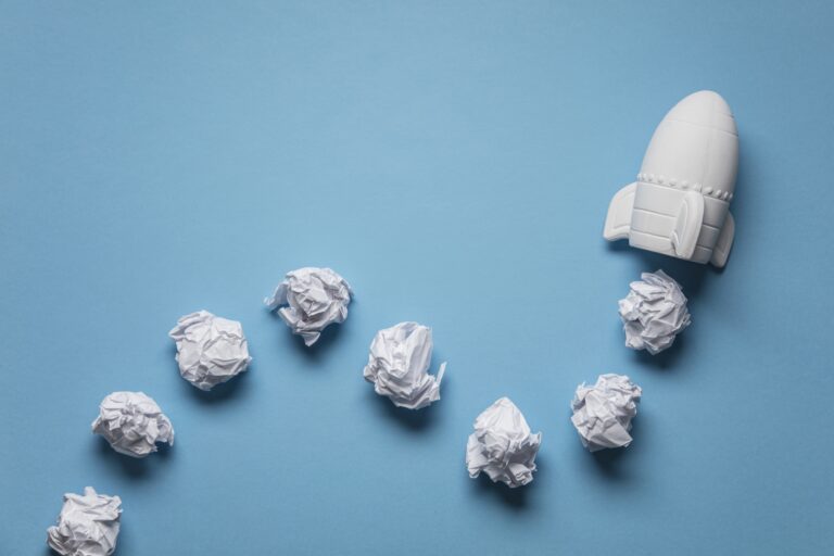 Business startup concept. Rocket taking off with crumpled paper trail