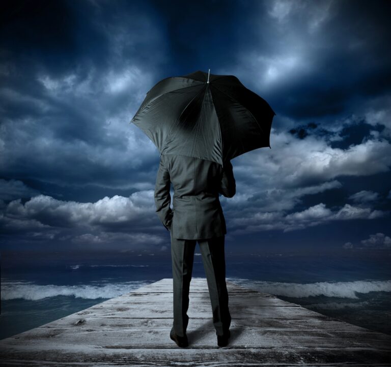 business man with umbrella looking at stormy skies